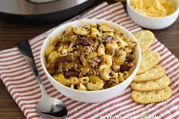 instant pot chili mac with beans and cheese in a white bowl with butter crackers