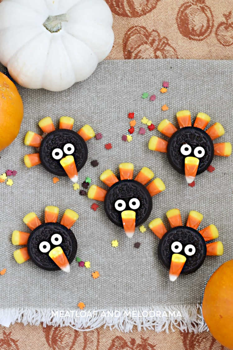 Oreo turkeys made from oreo cookies and candy corn on a thanksgiving tablecloth