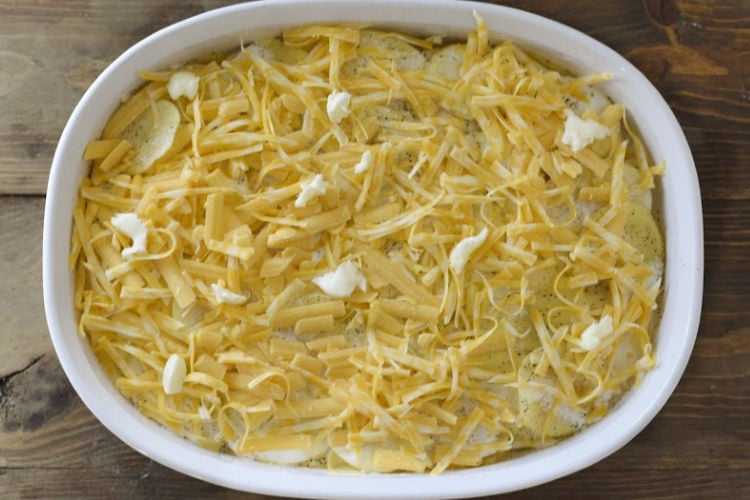 layered potatoes and shredded cheese in a white baking dish