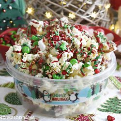 christmas crunch snack mix made with popcorn pretzels and candy in a holiday container