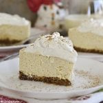 slice of instant pot eggnog cheesecake with eggnog whipped cream on a plate