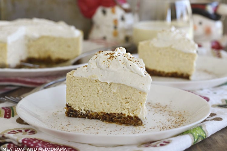 slice of instant pot eggnog cheesecake with eggnog whipped cream on a plate