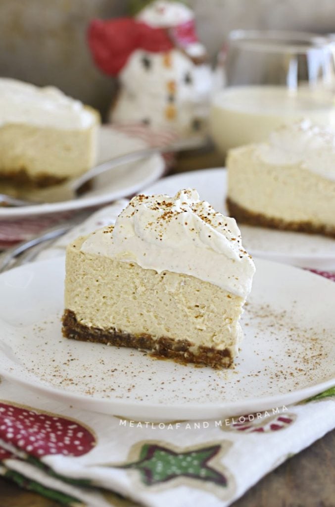 slice of eggnog cheesecake with whipped cream and nutmeg on a plate