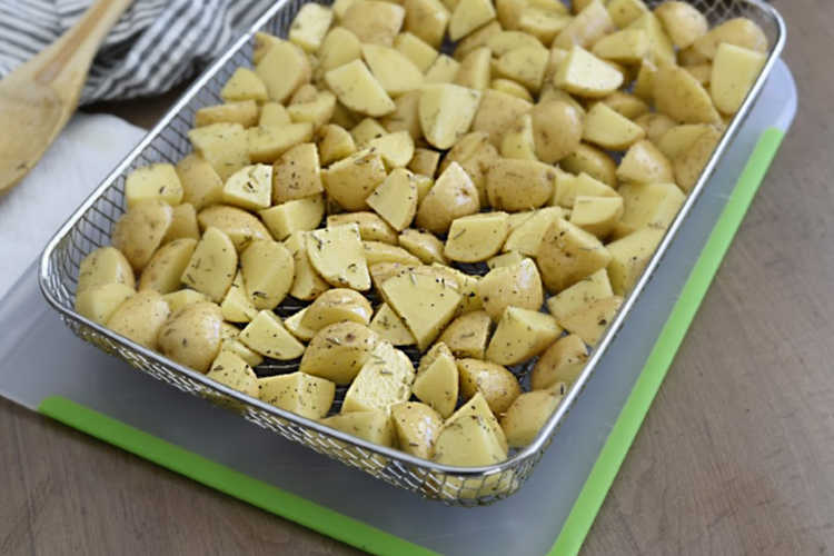 seasoned quartered baby potatoes in air fryer basket