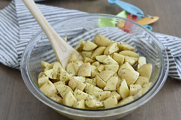 mix baby potatoes with seasoning  in mixing bowl