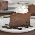 slice of instant pot chocolate cheesecake with whipped cream on a white plate