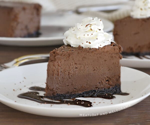 slice of instant pot chocolate cheesecake with whipped cream on a white plate