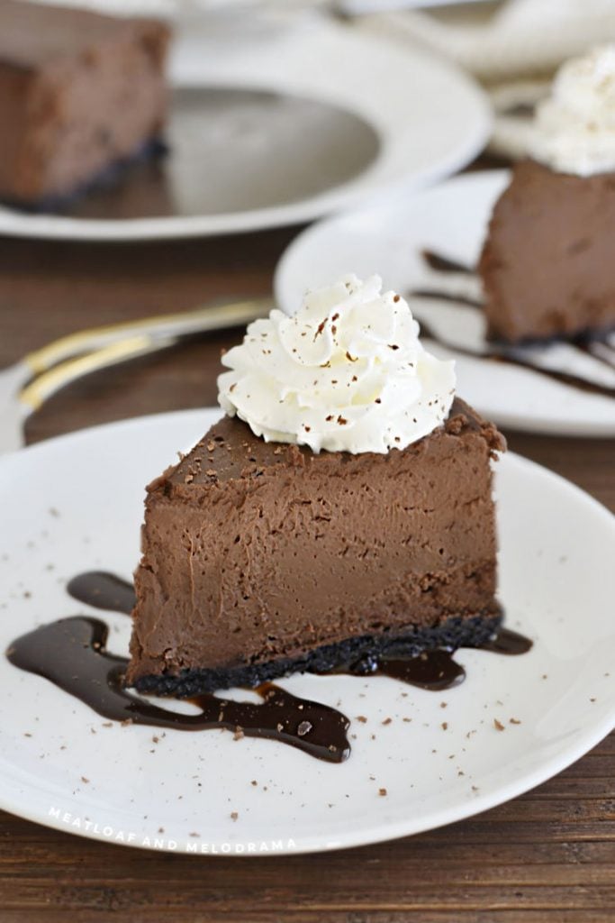 slice of chocolate cheesecake with whipped cream and chocolate shavings