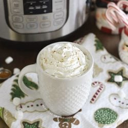 cup of hot chocolate with whipped cream in front of an instant pot
