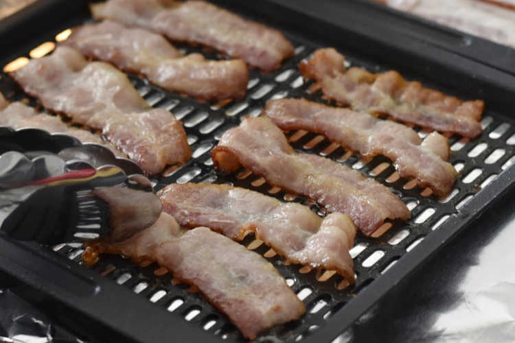 turn bacon over with tongs