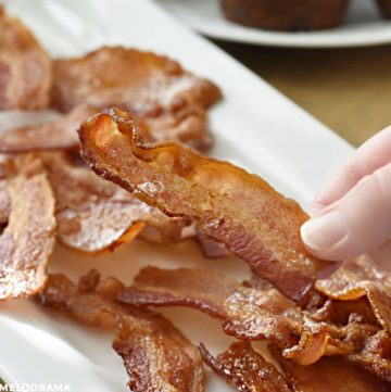 hand holding slice of crispy bacon