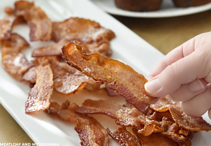 hand holding slice of crispy bacon