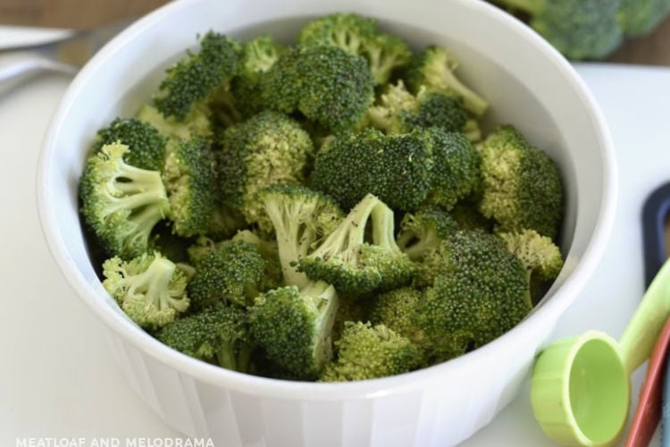 cut up broccoli florets in white bowl