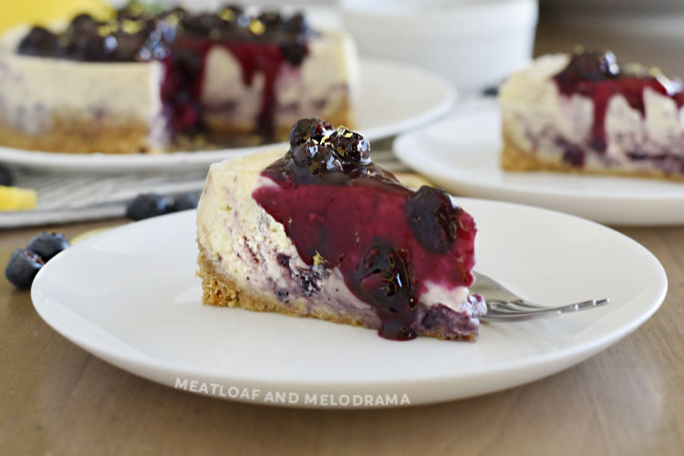 slice of lemon blueberry cheesecake with blueberry sauce on top and sides