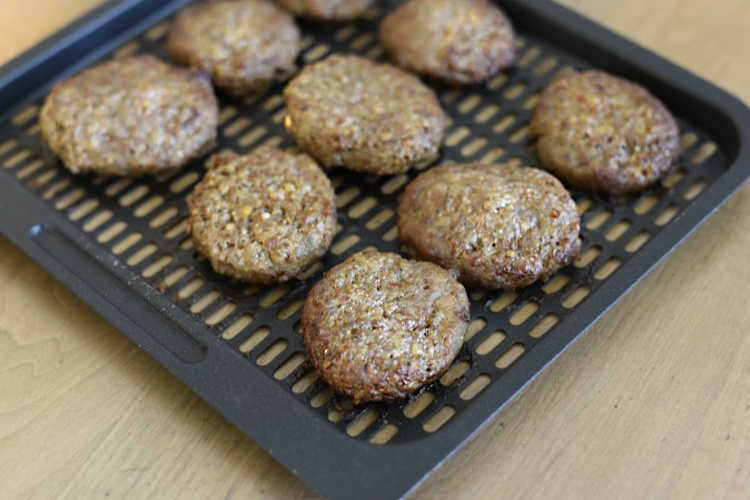 cooked breakfast sausage patties on air fryer tray