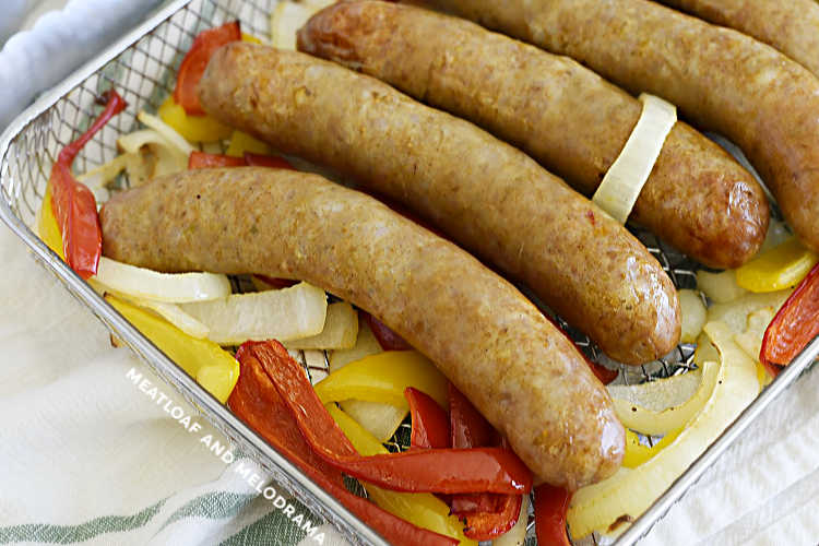 Italian sausages cooked with red and yellow bell peppers and onions in air fryer oven tray