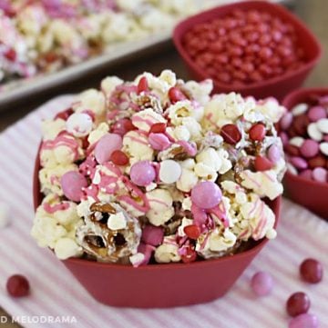 valentines day popcorn snack with red, pink and white candy in a red bowl