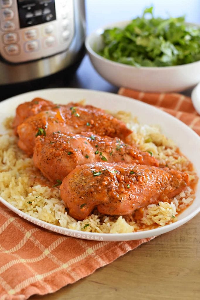 apricot chicken on a platter next to instant pot and bowl of salad