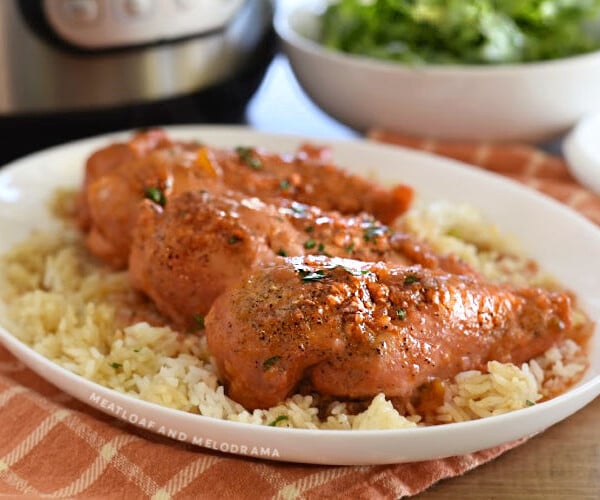 apricot chicken breasts over rice on a white platter