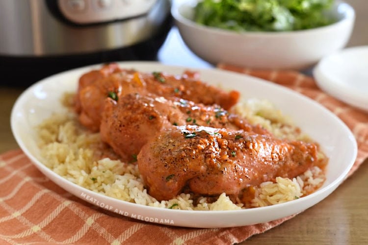 apricot chicken breasts over rice on a white platter