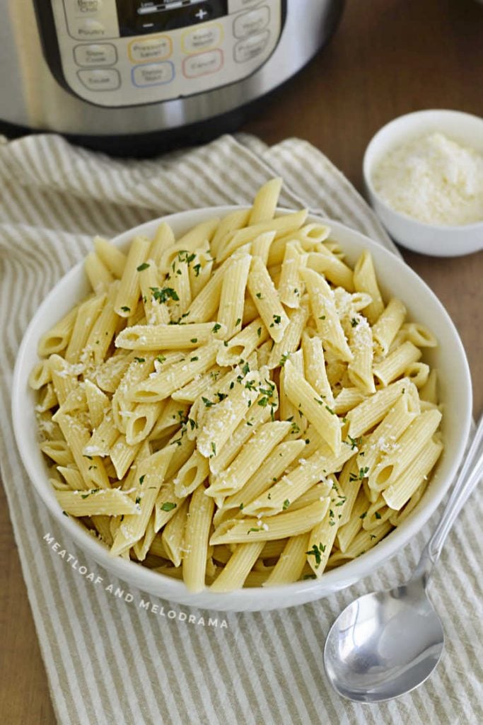 bowl of penne pasta next to an instant pot