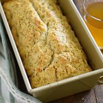 rosemary beer bread in loaf pan with glass of beer
