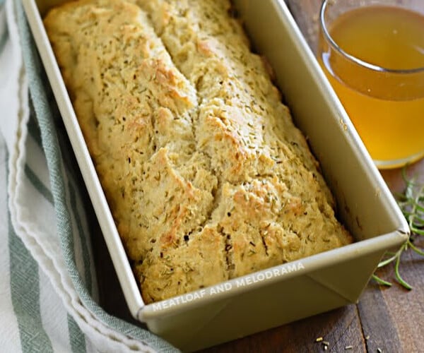 rosemary beer bread in loaf pan with glass of beer