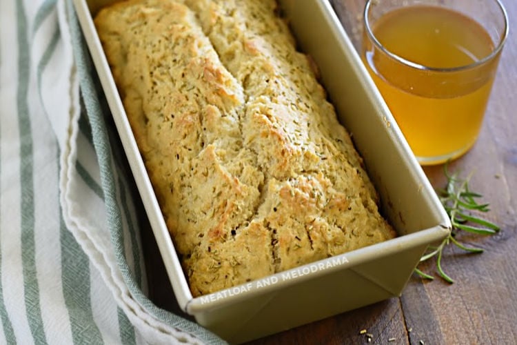 rosemary beer bread in loaf pan with glass of beer