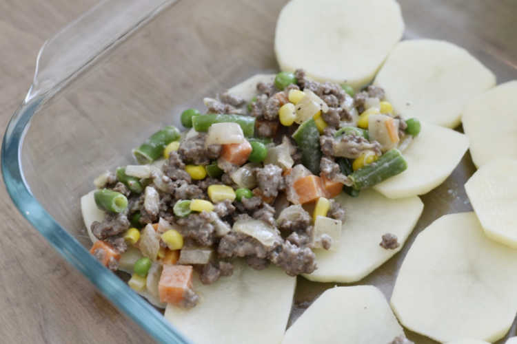 layer potatoes and ground beef in casserole dish