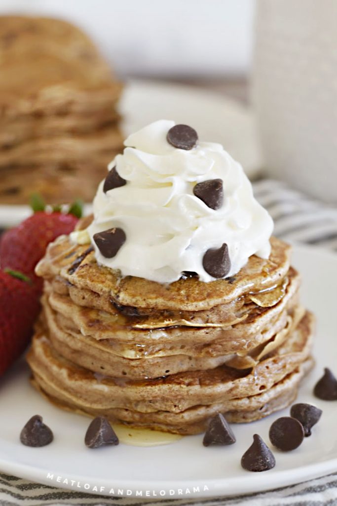 stack of pancakes with chocolate chips and whipped cream