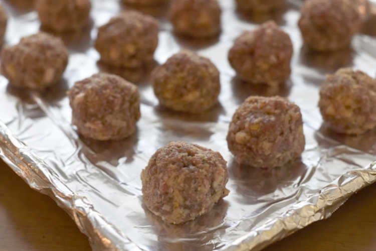 uncooked meatballs on baking sheet