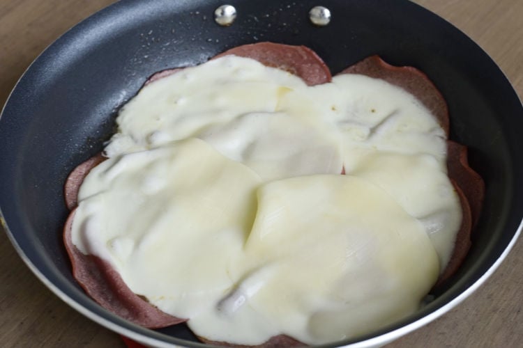 sliced bologna and melted provolone cheese in skillet