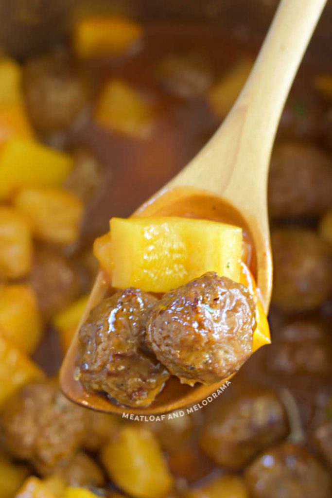  meatballs with pineapple chunks on wooden spoon