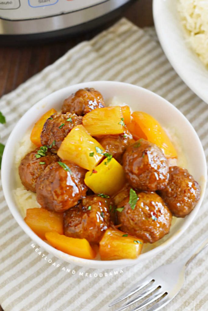 meatballs with sweet and sour sauce and pineapple chunks over rice