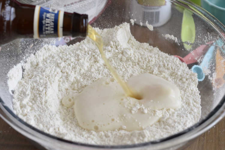 pour beer into flour mixture in mixing bowl