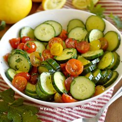 cucumber tomato salad in a white serving bowl