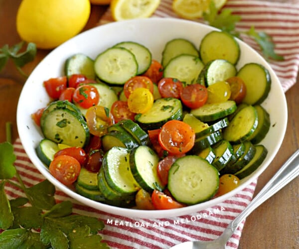 cucumber tomato salad in a white serving bowl