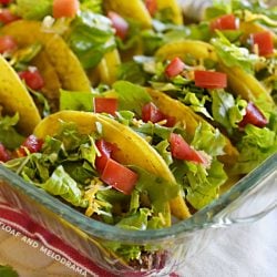 oven baked tacos with lettuce and tomatoes in a glass baking dish