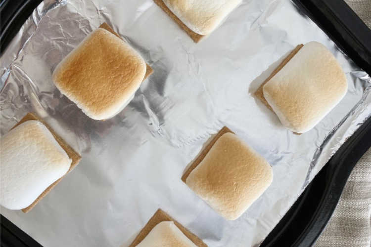 broiled marshmallows over graham crackers on baking sheet