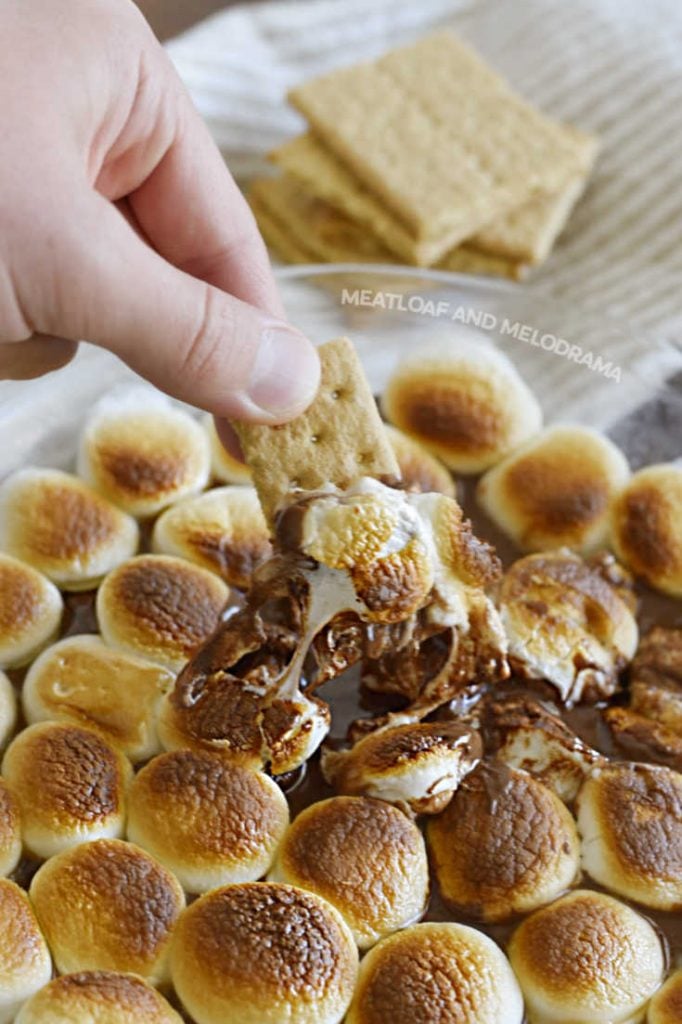 dip graham crackers into melted chocolate and marshmallows