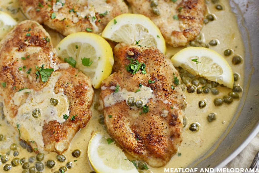 chicken piccata in cream sauce with lemon slices in a skillet