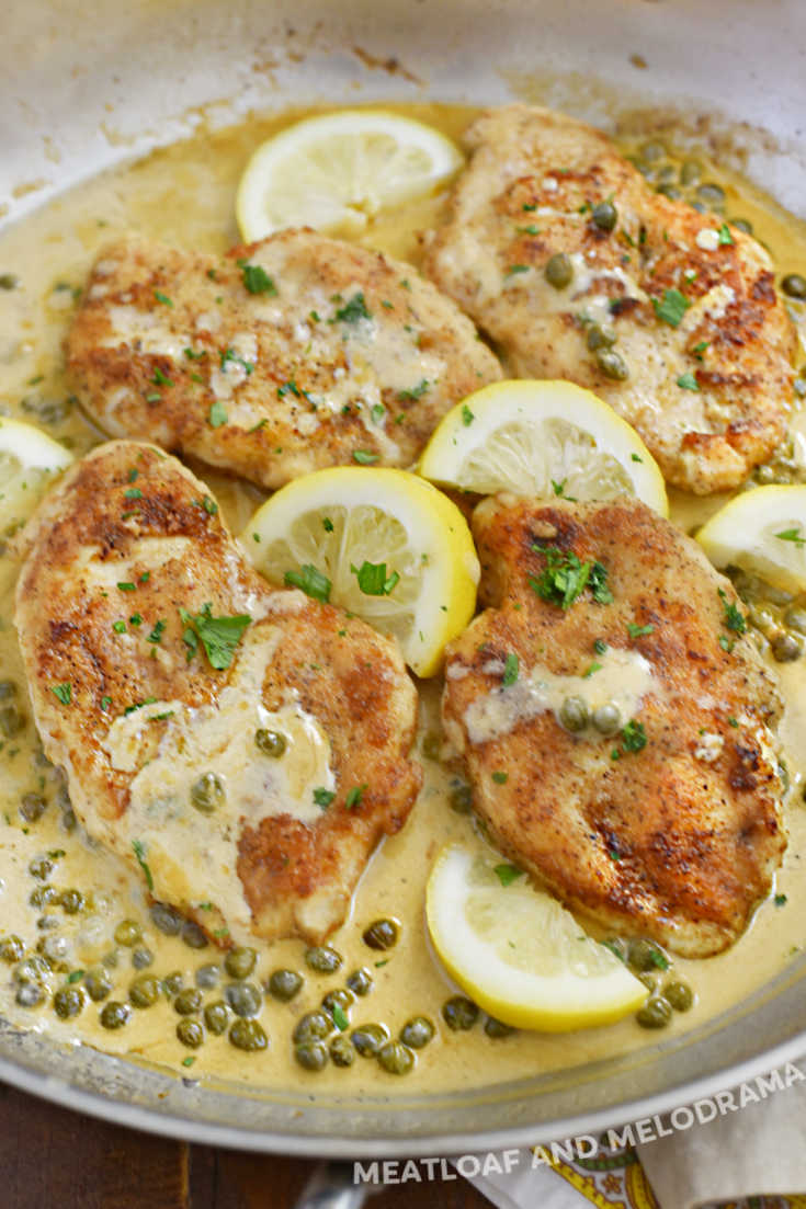 chicken cutlets with lemon slices and capers in a skillet