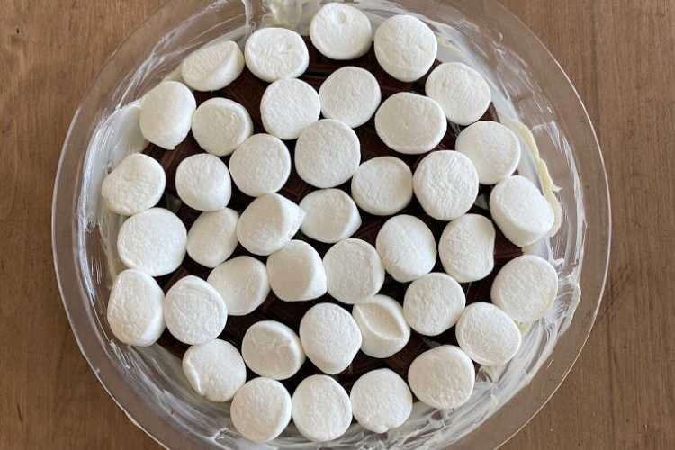 marshmallows over chocolate bars in glass pan