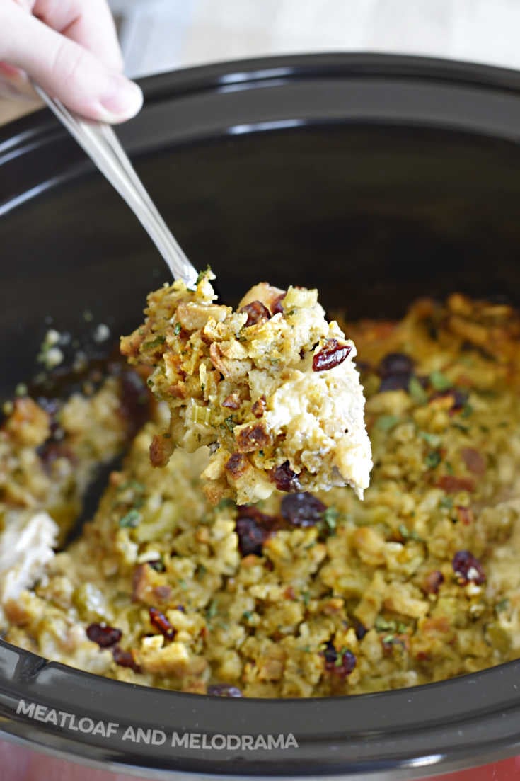 chicken and stuffing on serving spoon over slow cooker