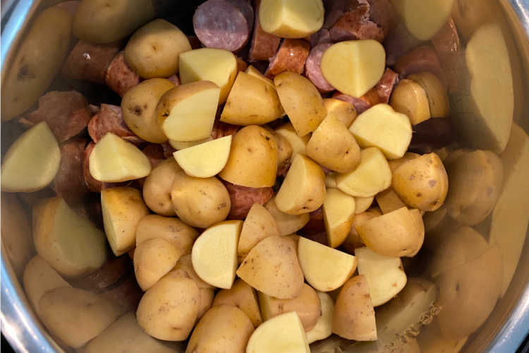 cut up potatoes over smoked sausage in the pressure cooker