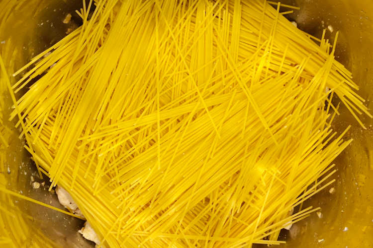 uncooked dry spaghetti noodles layered in instant pot