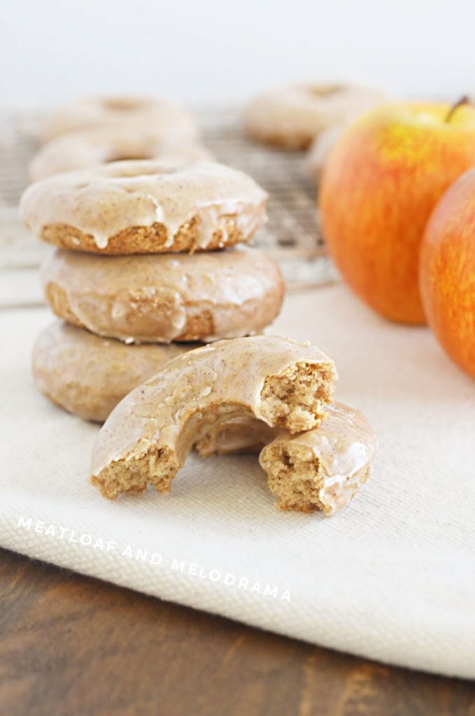 2 ingredient apple donuts stacked up with one cut in half on the table