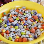 fall puppy chow muddy buddies in a yellow bowl with halloween candy
