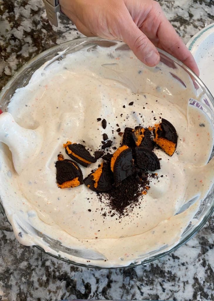 crushed halloween oreos in cream and milk mixture
