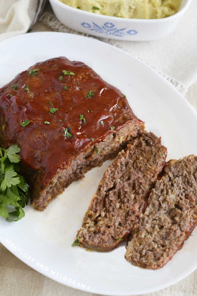 lipton onion soup meatloaf sliced in half on a white platter with mashed potatoes